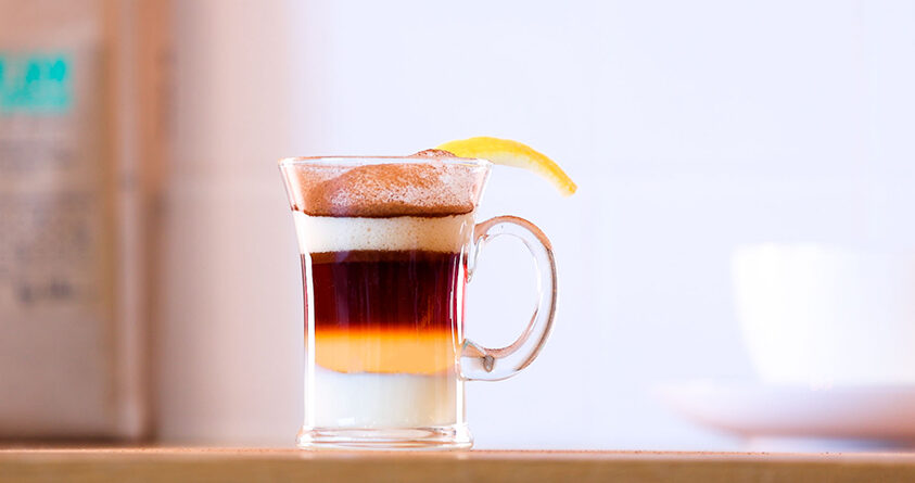 Et glass med alkoholfri barraquito står på en kjøkkenbenk