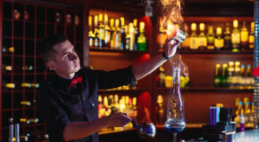 En bartender lager café brûlot ved å sette fyr på alkoholen
