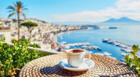 En espressokopp står på et bord med utsikt over Napoli