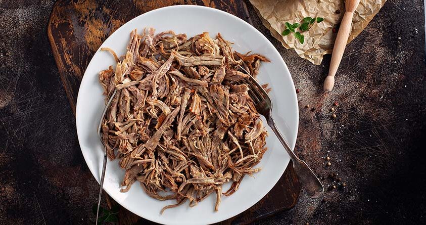 En tallerken med pulled pork står på en kjøkkenbenk