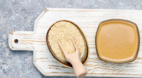 En skål med tahini står ved siden av en skål med sesamfrø