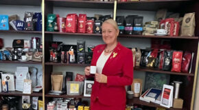 Maja Wallengren står foran mange hyller med kaffe