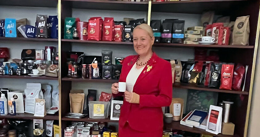 Maja Wallengren står foran mange hyller med kaffe