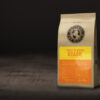 En pose med Poços de Caldas fra Coffee of the World står på et mørkt underlag