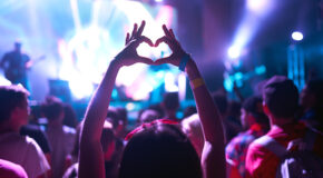 En kvinne er på rave og holder opp hendene i et hjerte