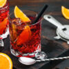 To glass med espresso negroni står på en mørk trefjøl