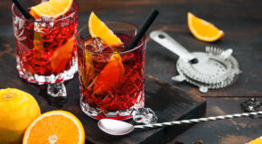To glass med espresso negroni står på en mørk trefjøl