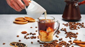 En person heller melk oppi en krydderkaffe