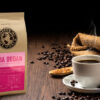 En pose med Baba Budan står ved siden av en kopp med kaffe