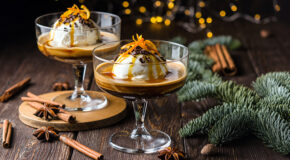 To serveringsglass med julekrydret affogato står på en trebenk