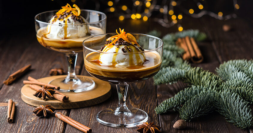 To serveringsglass med julekrydret affogato står på en trebenk