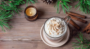 En kaffe latte med lakrisrot står på en trebenk