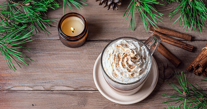 En kaffe latte med lakrisrot står på en trebenk