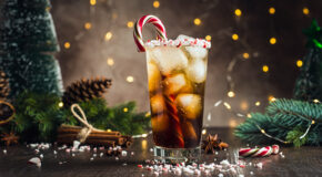 Et glass med kaffe tonic med peppermynte står på en julepyntet kjøkkenbenk