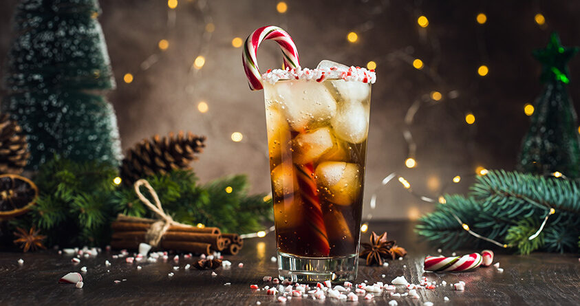 Et glass med kaffe tonic med peppermynte står på en julepyntet kjøkkenbenk