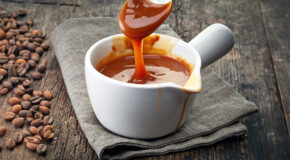 En skje rører oppi en beholder med kaffekaramellsaus