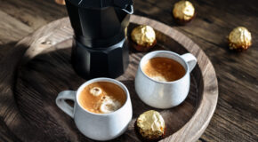 To små kopper med colada-kaffe og en mokkakanne står på et serveringsbrett i tre