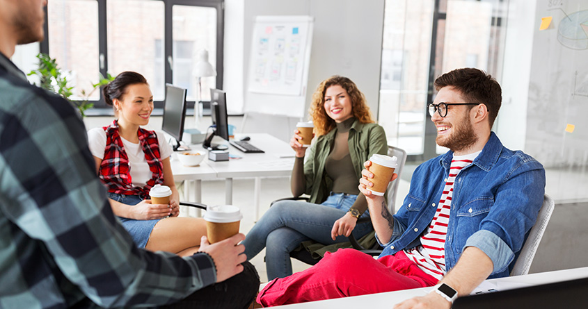 Fire kolleger tar en kaffepause på et kontor