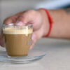 En person holder en kopp med cà phê muối