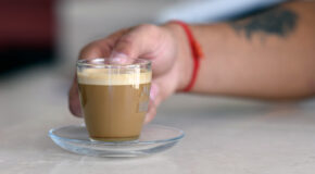 En person holder en kopp med cà phê muối