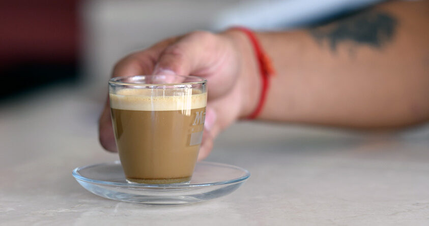 En person holder en kopp med cà phê muối