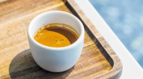 En cafezinho står på et trebrett