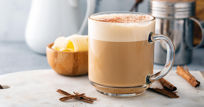 En kopp med smørkaffe står på en kjøkkenbenk
