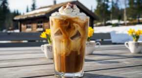 Et glass med påskeiskaffe står på et bord ute i solskinnet