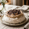 En pavlova med kaffekrem og mørk sjokolade står servert på et bord