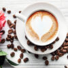 En kopp kaffe med lattekunst i form av et hjerte står på et bord