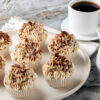 Tiramisu-muffins står på en hvit asjett ved siden av kaffekopp og en mugge med melk